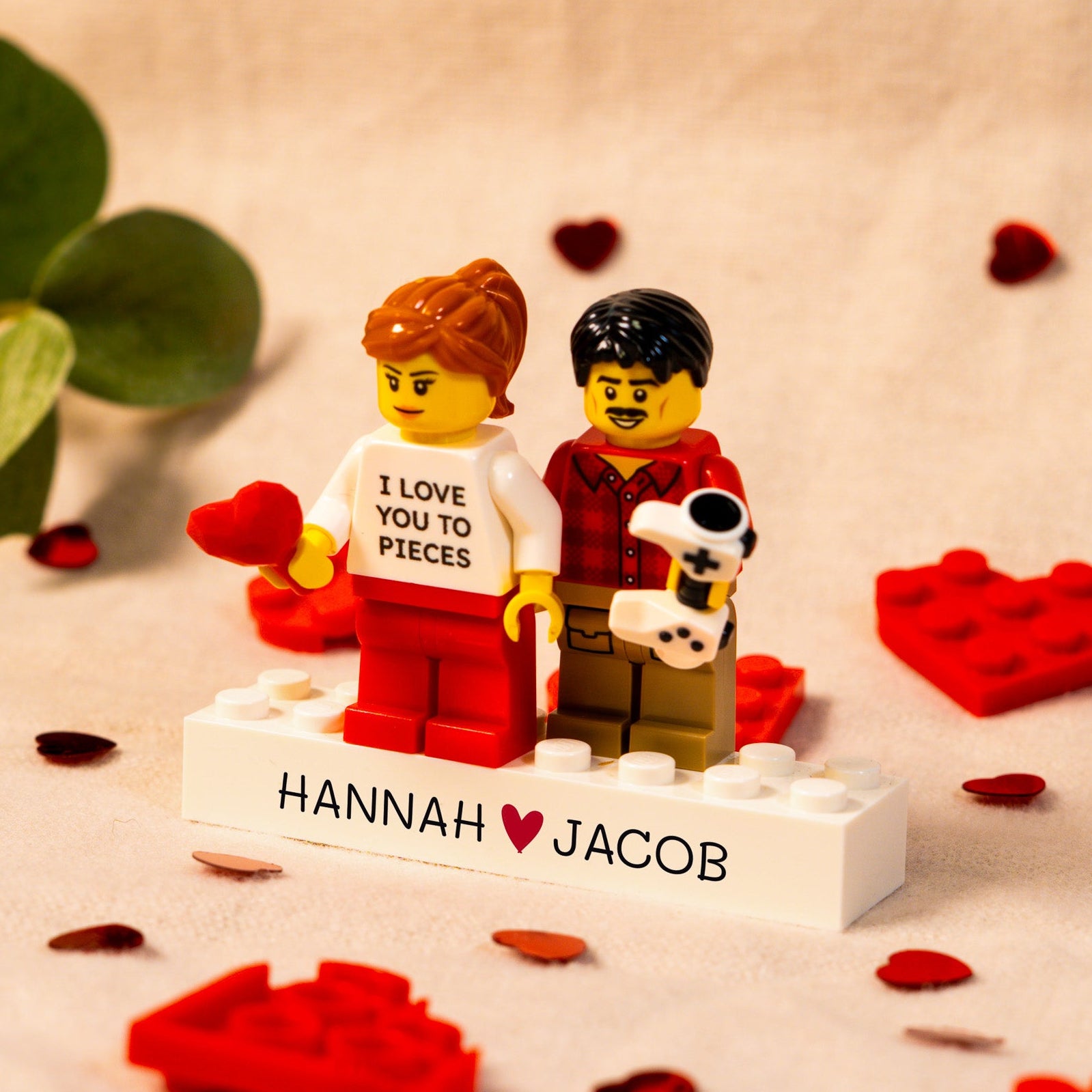 Two LEGO brick figures with a brick platform displaying 'I Love You to Pieces' and 'Hannah ♥ Jacob'.